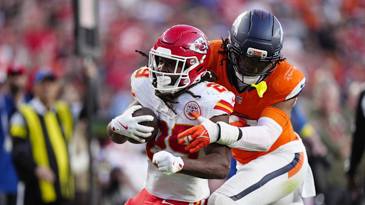 Nov 16, 2025; Denver, Colorado, USA; Denver Broncos linebacker Nik Bonitto (15) tackles Kansas City Chiefs running back Kareem Hunt (29) carries the ball in the third quarter at Empower Field at Mile High. Mandatory Credit: Ron Chenoy-Imagn Images