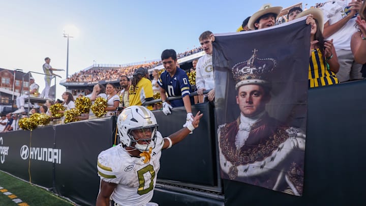 Oct 11, 2025; Atlanta, Georgia, USA; Georgia Tech Yellow Jackets running back Malachi Hosley (0) celebrates with fans holding a flag of quarterback Haynes King (not pictured) after a victory over the Virginia Tech Hokies in the fourth quarter at Bobby Dodd Stadium at Hyundai Field. Mandatory Credit: Brett Davis-Imagn Images
Oct 11, 2025; Atlanta, Georgia, USA; Georgia Tech Yellow Jackets running back Malachi Hosley (0) celebrates with fans holding a flag of quarterback Haynes King (not pictured) after a victory over the Virginia Tech Hokies in the fourth quarter at Bobby Dodd Stadium at Hyundai Field. Mandatory Credit: Brett Davis-Imagn Images