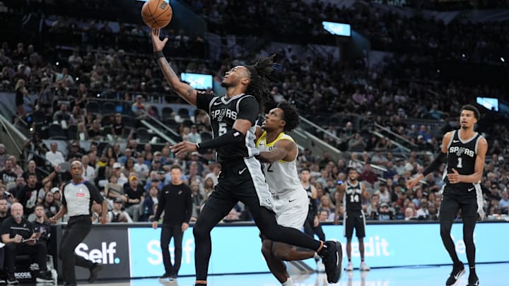 Nov 9, 2024; San Antonio, Texas, USA;  San Antonio Spurs guard Stephon Castle (5) puts the ball up in front of Utah Jazz guard Collin Sexton (2) in the second half at Frost Bank Center. Mandatory Credit: Daniel Dunn-Imagn Images