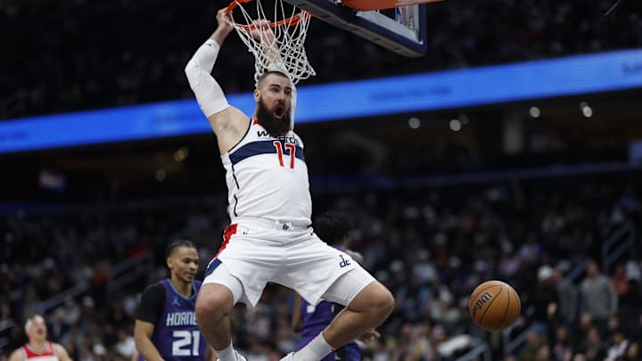 Dec 19, 2024; Washington, District of Columbia, USA; Washington Wizards center Jonas Valanciunas (17) dunks the ball as Charlotte Hornets guard Isaiah Wong (21) looks on in the fourth quarter at Capital One Arena. Mandatory Credit: Geoff Burke-Imagn Images