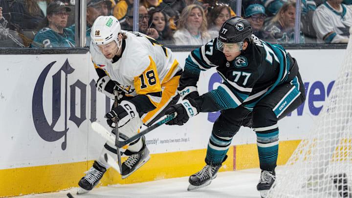 Oct 18, 2025; San Jose, California, USA; Pittsburgh Penguins center Tommy Novak (18) and San Jose Sharks center Michael Misa (77) battle for the puck behind the net during first perioid at SAP Center at San Jose. Mandatory Credit: Neville E. Guard-Imagn Images