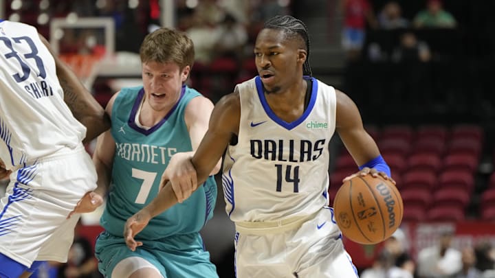Jul 14, 2025; Las Vegas, NV, USA; Dallas Mavericks guard Miles Kelly (14) dribbles the ball against Charlotte Hornets guard Kon Knueppel (7) during the first half of a NBA basketball game at Thomas & Mack Center. Mandatory Credit: Lucas Peltier-Imagn Images