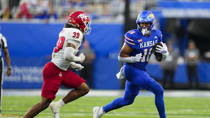 Aug 23, 2025; Lawrence, Kansas, USA; Kansas Jayhawks tight end DeShawn Hanika (18) runs with the ball against Fresno State Bulldogs linebacker Jadon Pearson (39) during the second half at David Booth Kansas Memorial Stadium. Mandatory Credit: Jay Biggerstaff-Imagn Images
