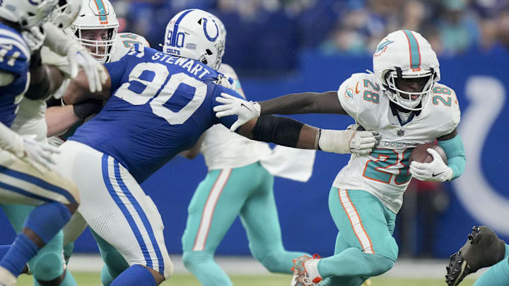 Miami Dolphins running back De'Von Achane (28) rushes past Indianapolis Colts defensive tackle Grover Stewart (90) during a game against the Miami Dolphins at Lucas Oil Stadium.