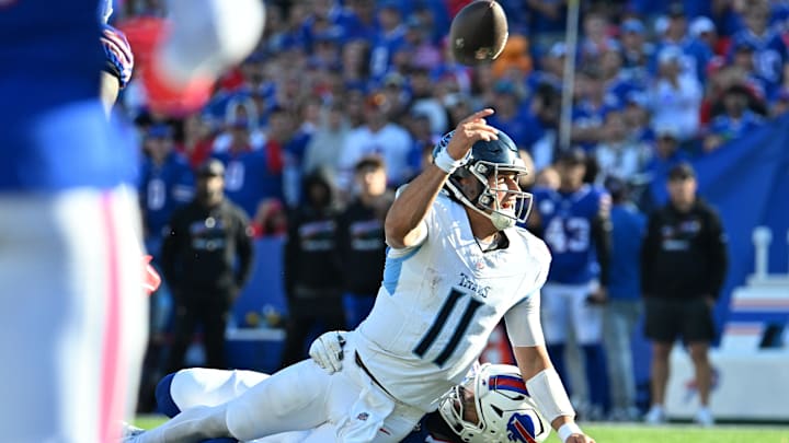 Oct 20, 2024; Orchard Park, New York, USA; Tennessee Titans quarterback Mason Rudolph (11) throws a pass while beig tackled by Buffalo Bills defensive tackle DaQuan Jones (92) in the fourth quarter at Highmark Stadium. Mandatory Credit: Mark Konezny-Imagn Images