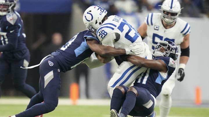 Dec 22, 2024; Indianapolis, Indiana, USA; Tennessee Titans cornerback Chidobe Awuzie (13) and Tennessee Titans linebacker Otis Reese IV (41) wrap up Indianapolis Colts running back Jonathan Taylor (28) during a game against the Tennessee Titans  at Lucas Oil Stadium. Mandatory Credit: Christine Tannous/USA Today Network via Imagn Images 