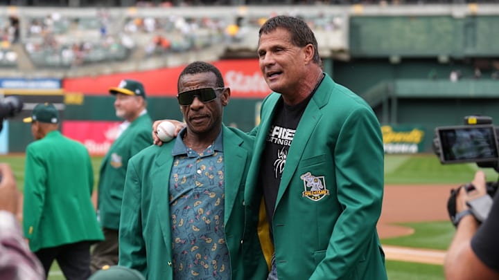 Oakland Athletics former outfielders Rickey Henderson (left) and Jose Canseco (right) walk on the field before the game against the San Francisco Giants at Oakland-Alameda County Coliseum. 