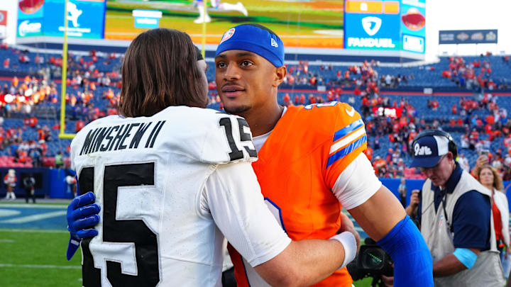 Oct 6, 2024; Denver, Colorado, USA; Las Vegas Raiders quarterback Gardner Minshew (15) and Denver Broncos cornerback Pat Surtain II (2) following the game at Empower Field at Mile High. Mandatory Credit: Ron Chenoy-Imagn Images