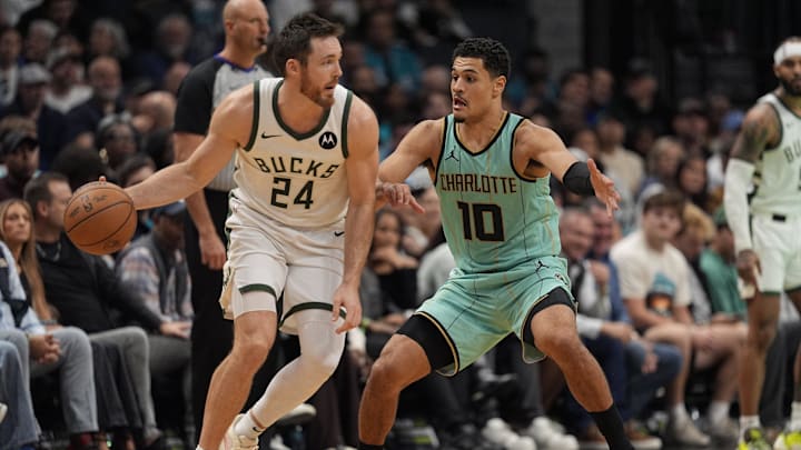 Nov 16, 2024; Charlotte, North Carolina, USA; Milwaukee Bucks guard Pat Connaughton (24) handles the ball against Charlotte Hornets guard Josh Green (10) during the second half at Spectrum Center. Mandatory Credit: Jim Dedmon-Imagn Images