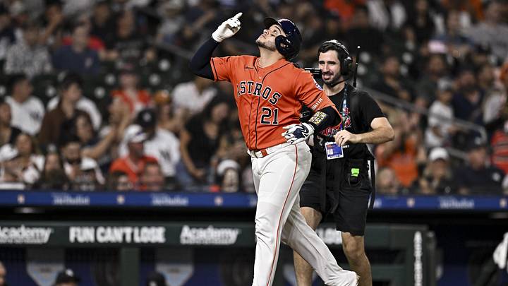 Houston Astros catcher Yainer Diaz celebrates wearing an orange jersey and navy blue helmet.