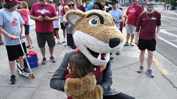 Sep 7, 2024; Pullman, Washington, USA; Washington State Cougars mascot Butch gets a hug from a young Washington State Cougars fan before a game against the Texas Tech Red Raiders at Gesa Field at Martin Stadium. Mandatory Credit: James Snook-Imagn Images