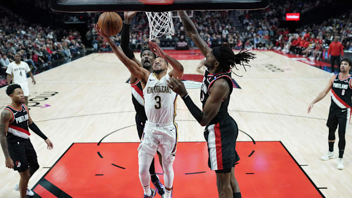 Oct 25, 2024; Portland, Oregon, USA; New Orleans Pelicans shooting guard CJ McCollum (3) drives to the basket under pressure from Portland Trail Blazers center Deandre Ayton (2, behind) during the second half at Moda Center. Mandatory Credit: Soobum Im-Imagn Images