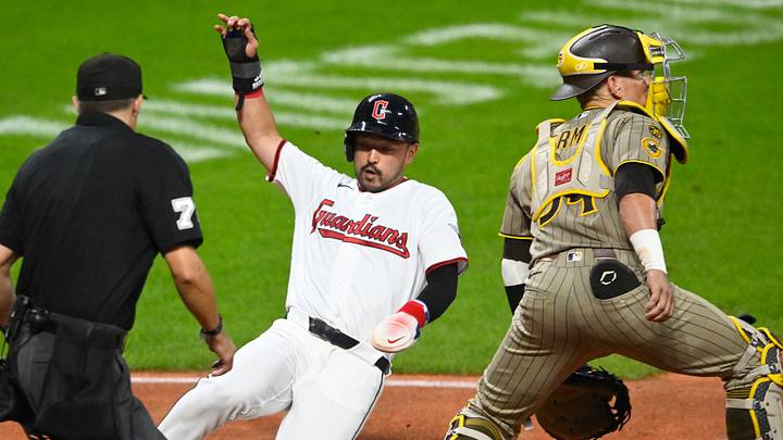 Aug 15, 2026; Cleveland, Ohio, USA; Cleveland Guardians left fielder Steven Kwan (38) scores beside San Diego Padres catcher Freddy Fermin (54) in the fifth inning at Progressive Field. Mandatory Credit: David Richard-Imagn Images
