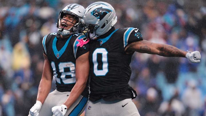 Nov 30, 2025; Charlotte, North Carolina, USA;  Carolina Panthers wide receiver Jalen Coker (18) celebrates with Carolina Panthers tight end Ja'Tavion Sanders (0) after scoring a touchdown during the third quarter against the Los Angeles Ramsat Bank of America Stadium. Mandatory Credit: Scott Kinser-Imagn Images