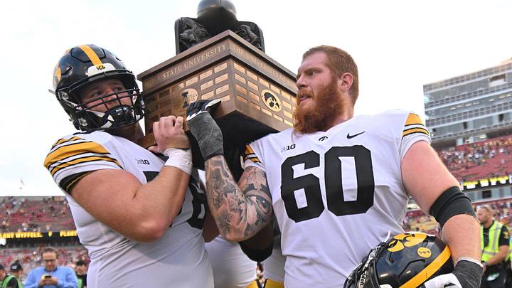 Sep 9, 2023; Ames, Iowa, USA; Iowa Hawkeyes offensive lineman Mason Richman (78) and offensive lineman Rusty Feth (60) carry the Cy-Hawk trophy after the game against the Iowa State Cyclones at Jack Trice Stadium. Mandatory Credit: Jeffrey Becker-Imagn Images