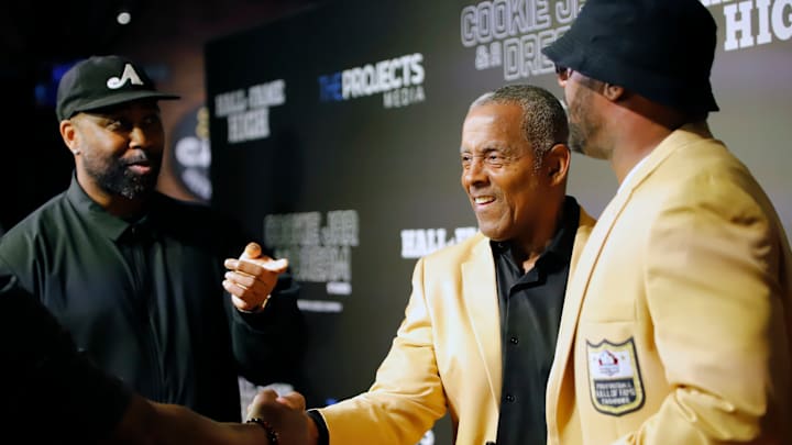 Pro Football Hall of Famer Tony Dorsett, a Hopewell graduate,  shakes hands with a member of the crowd at the debut of the film "Hall of Fame High" which is a documentary about the Aliquippa football program, Wednesday at the Heinz History Center. Darrelle Revis (left) and Ty Law (right) are graduates of Aliquippa High School who went onto Pro Football Hall of Fame careers.