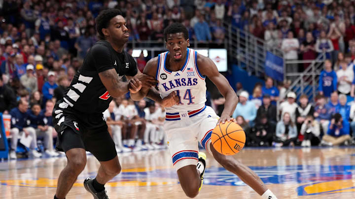 Feb 21, 2026; Lawrence, Kansas, USA; Kansas Jayhawks guard Melvin Council Jr. (14) dribbles the ball as Cincinnati Bearcats guard Jizzle James (2) defends during the first half of the game at Allen Fieldhouse. Mandatory Credit: Denny Medley-Imagn Images
