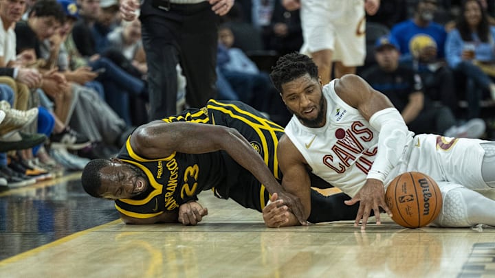 Nov 11, 2023; San Francisco, California, USA;  Golden State Warriors forward Draymond Green (23) and Cleveland Cavaliers guard Donovan Mitchell (45) dive for the ball during the third quarter at Chase Center. Mandatory Credit: Neville E. Guard-Imagn Images