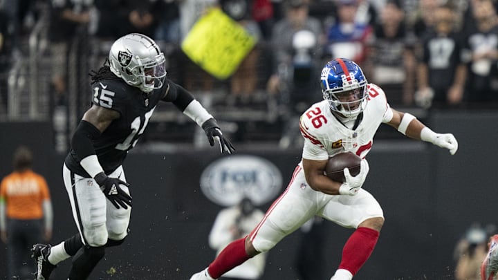 November 5, 2023; Paradise, Nevada, USA; New York Giants running back Saquon Barkley (26) runs the football against Las Vegas Raiders linebacker Jaylon Smith (15) during the first quarter at Allegiant Stadium. Mandatory Credit: Kyle Terada-Imagn Images