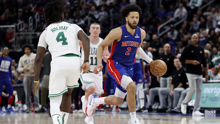 Feb 26, 2025; Detroit, Michigan, USA;  Detroit Pistons guard Cade Cunningham (2) dribbles defended by Boston Celtics guard Jrue Holiday (4) in the second half at Little Caesars Arena. Mandatory Credit: Rick Osentoski-Imagn Images