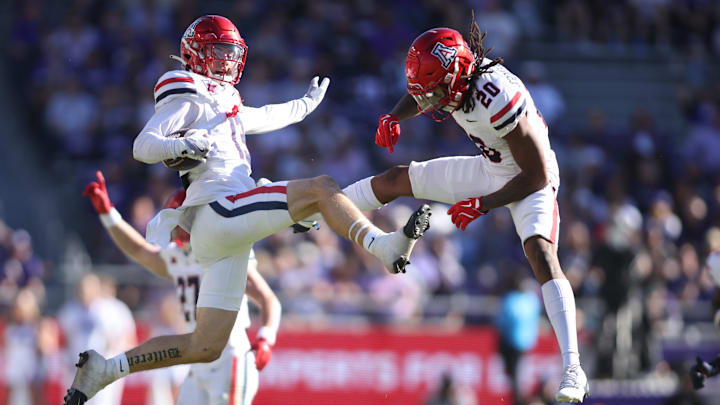Nov 23, 2024; Fort Worth, Texas, USA; Arizona Wildcats defensive back Jack Luttrell (13) and defensive back Marquis Groves-Killebrew (20) celebrate an interception in the first quarter against the TCU Horned Frogs  at Amon G. Carter Stadium. Mandatory Credit: Tim Heitman-Imagn Images