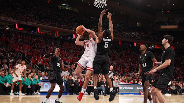 Jan 25, 2025; New York, New York, USA; Rutgers Scarlet Knights guard Jordan Derkack (0) goes to the basket as Michigan State Spartans guard Tre Holloman (5) defends during the first half at Madison Square Garden. Mandatory Credit: Vincent Carchietta-Imagn Images