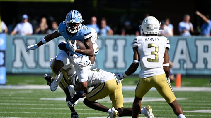 Oct 12, 2024; Chapel Hill, North Carolina, USA; North Carolina Tar Heels wide receiver Kobe Paysour (8) with the ball as Georgia Tech Yellow Jackets defensive backs Clayton Powell-Lee (5) and Omar Daniels (21) and  Ahmari Harvey (3) defend in the fourth quarter at Kenan Memorial Stadium. Mandatory Credit: Bob Donnan-Imagn Images