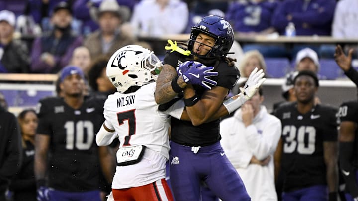 Nov 29, 2025; Fort Worth, Texas, TCU Horned Frogs wide receiver Jordan Dwyer (7) catches a pass over Cincinnati Bearcats cornerback Logan Wilson (7) and runs for a touchdown during the first half at Amon G. Carter Stadium. Mandatory Credit: Jerome Miron-Imagn Images