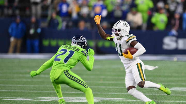 Dec 15, 2024; Seattle, Washington, USA; Green Bay Packers wide receiver Jayden Reed (11) carries the ball after a catch while defended by Seattle Seahawks cornerback Devon Witherspoon (21) during the first half at Lumen Field. Mandatory Credit: Steven Bisig-Imagn Images
