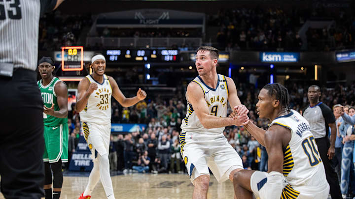 Jan 8, 2024; Indianapolis, Indiana, USA; Indiana Pacers guard T.J. McConnell (9) helps up Indiana Pacers guard Bennedict Mathurin (00) after a foul  in the second half against the Boston Celtics at Gainbridge Fieldhouse. Mandatory Credit: Trevor Ruszkowski-Imagn Images