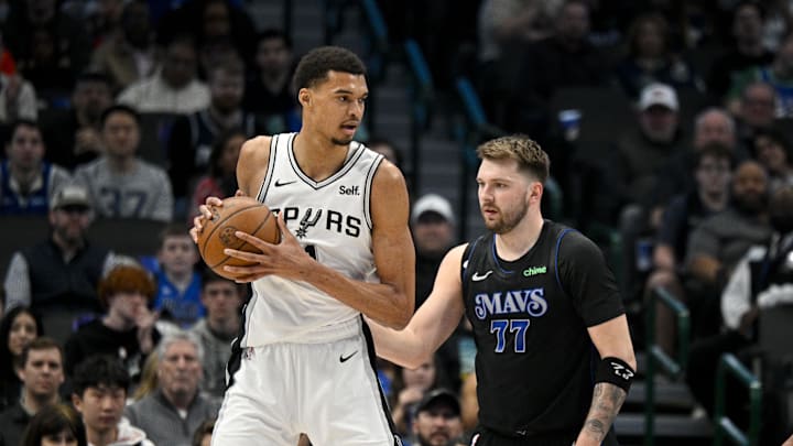 Feb 14, 2024; Dallas, Texas, USA; San Antonio Spurs center Victor Wembanyama (1) looks to move the ball past Dallas Mavericks guard Luka Doncic (77) during the fist quarter at the American Airlines Center. Mandatory Credit: Jerome Miron-Imagn Images