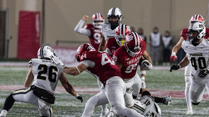 Nov 30, 2024; Bloomington, Indiana, USA; Indiana Hoosiers defensive lineman James Carpenter (99) runs the ball on a fake punt while Purdue Boilermakers fullback Ben Furtney (41) defends in the second half at Memorial Stadium. Mandatory Credit: Trevor Ruszkowski-Imagn Images