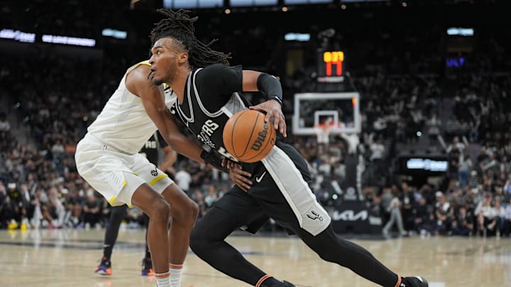 Nov 9, 2024; San Antonio, Texas, USA;  San Antonio Spurs guard Stephon Castle (5) drives past Utah Jazz forward Cody Williams (5) in the second half at Frost Bank Center. Mandatory Credit: Daniel Dunn-Imagn Images
