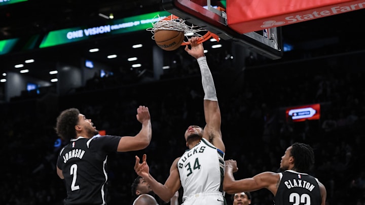 Dec 8, 2024; Brooklyn, New York, USA; Milwaukee Bucks forward Giannis Antetokounmpo (34) dunks the ball as Brooklyn Nets forward Cameron Johnson (2) and Brooklyn Nets center Nic Claxton (33) defend during the second half at Barclays Center. Mandatory Credit: John Jones-Imagn Images