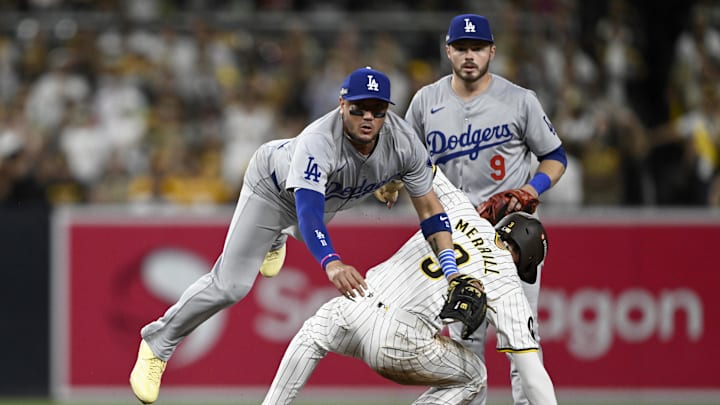Oct 8, 2024; San Diego, California, USA; Los Angeles Dodgers shortstop Miguel Rojas (11) throws late to first after not forcing out San Diego Padres outfielder Jackson Merrill (3) at second in the second inning during game three of the NLDS for the 2024 MLB Playoffs at Petco Park.  Mandatory Credit: Denis Poroy-Imagn Images