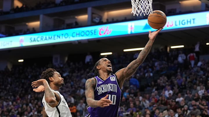 Nov 24, 2024; Sacramento, California, USA; Sacramento Kings forward DeMar DeRozan (10) shoots against Brooklyn Nets center Nic Claxton (left) during the fourth quarter at Golden 1 Center. Mandatory Credit: Darren Yamashita-Imagn Images