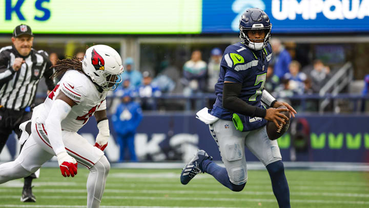 Nov 24, 2024; Seattle, Washington, USA; Seattle Seahawks quarterback Geno Smith (7) rushes against the Arizona Cardinals during the second quarter at Lumen Field. Mandatory Credit: Joe Nicholson-Imagn Images