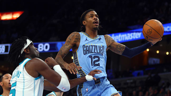Jan 22, 2025; Memphis, Tennessee, USA; Memphis Grizzlies guard Ja Morant (12) drives to the basket as Charlotte Hornets center Mark Williams (5) defends during the third quarter at FedExForum. Mandatory Credit: Petre Thomas-Imagn Images