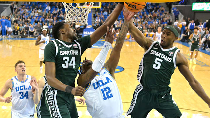 Feb 4, 2025; Los Angeles, California, USA; Michigan State Spartans forward Xavier Booker (34) and guard Tre Holloman (5) defend a shot by UCLA Bruins guard Sebastian Mack (12) in the first half at Pauley Pavilion presented by Wescom. Mandatory Credit: Jayne Kamin-Oncea-Imagn Images