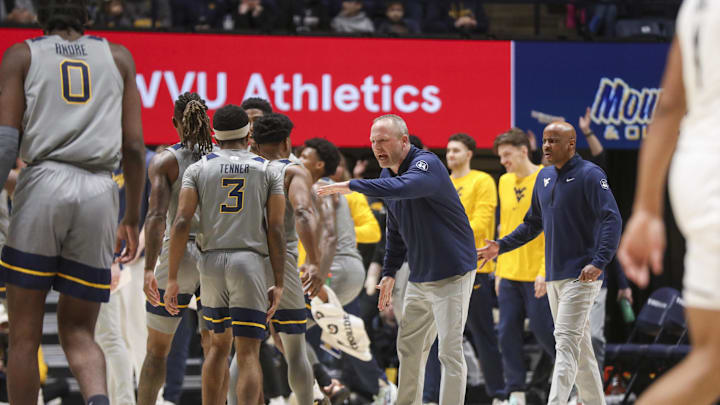 West Virginia Mountaineers head coach DeVries celebrates with players after a play against the UCF Knights.