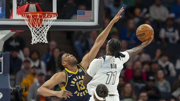 Mar 17, 2025; Minneapolis, Minnesota, USA; Minnesota Timberwolves center Naz Reid (11) drives to the basket and shoots the ball over Indiana Pacers center Tony Bradley (13) in the second half at Target Center. Mandatory Credit: Jesse Johnson-Imagn Images