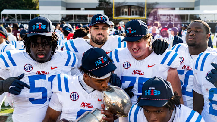 Ole Miss quarterback Trinidad Chambliss (6) kisses the Golden Egg trophy while posing for a picture with teammates after a college football game between Mississippi State and Ole Miss at Davis Wade Stadium in Starkville, Miss., on Friday, Nov. 28, 2025. Ole Miss defeated Mississippi State 38-19 in the Egg Bowl.