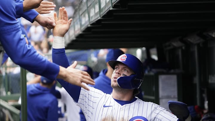 Chicago Cubs second baseman Nico Hoerner (2) is greeted in the dugout after scoring against the Cincinnati Reds during the fifth inning at Wrigley Field in 2024.