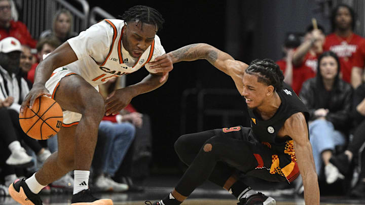 Feb 8, 2025; Louisville, Kentucky, USA;  Miami (Fl) Hurricanes guard Paul Djobet (10) dribbles against Louisville Cardinals forward Khani Rooths (9) during the second half at KFC Yum! Center. Louisville defeated Miami 88-78. Mandatory Credit: Jamie Rhodes-Imagn Images
