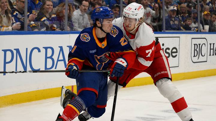 Apr 1, 2025; St. Louis, Missouri, USA; St. Louis Blues right wing Jimmy Snuggerud (21) battles Detroit Red Wings defenseman Simon Edvinsson (77) during the second period at Enterprise Center. Mandatory Credit: Jeff Le-Imagn Images