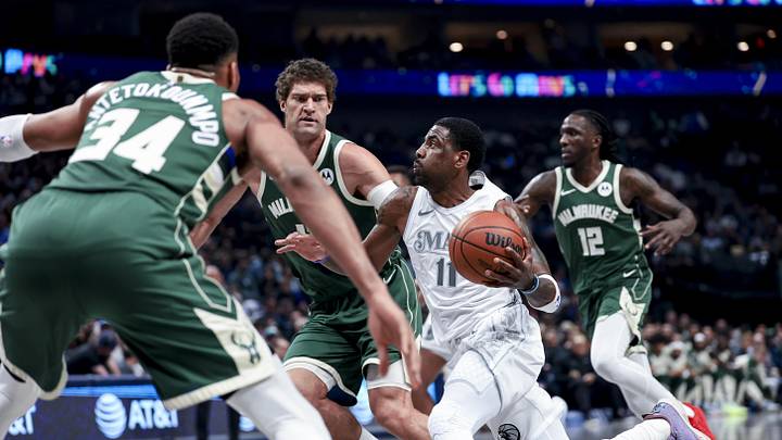 Mar 1, 2025; Dallas, Texas, USA;  Dallas Mavericks guard Kyrie Irving (11) drives to the basket as Milwaukee Bucks center Brook Lopez (11) and Milwaukee Bucks forward Giannis Antetokounmpo (34) defend during the first half at American Airlines Center. Mandatory Credit: Kevin Jairaj-Imagn Images