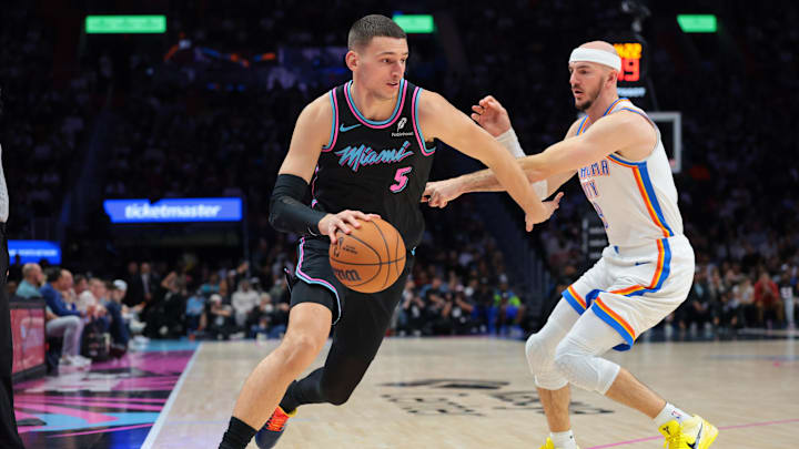 Jan 17, 2026; Miami, Florida, USA; Miami Heat forward Nikola Jovic (5) drives to the basket against Oklahoma City Thunder guard Alex Caruso (9) during the third quarter at Kaseya Center. Mandatory Credit: Sam Navarro-Imagn Images