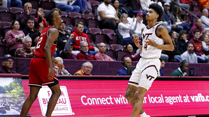 Jan 15, 2025; Blacksburg, Virginia, USA; Virginia Tech Hokies guard Rodney Brown Jr. (4) celebrates after making a three pointer against North Carolina State Wolfpack guard Paul McNeil (2) during the first half at Cassell Coliseum. Mandatory Credit: Peter Casey-Imagn Images