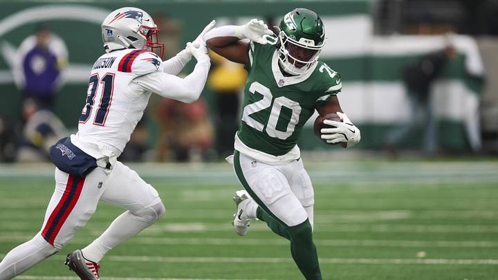New York Jets running back Breece Hall (20) runs the ball against New England Patriots safety Craig Woodson (31) during the second half of the game at MetLife Stadium.