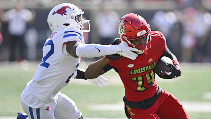 Oct 5, 2024; Louisville, Kentucky, USA;  Louisville Cardinals wide receiver Ahmari Huggins-Bruce (24) runs the ball against Southern Methodist Mustangs safety Cale Sanders Jr. (22) during the second half at L&N Federal Credit Union Stadium. Mandatory Credit: Jamie Rhodes-Imagn Images